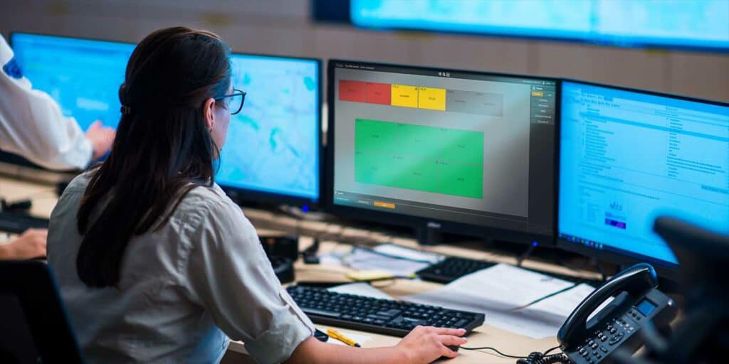 Female security guards working in surveillance room, monitoring cctv and discussing.