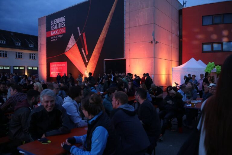 Crowd gathered at the Filmakademie Baden-Württemberg event, with a large banner in the background reading "Blending Realities FMX 2016"